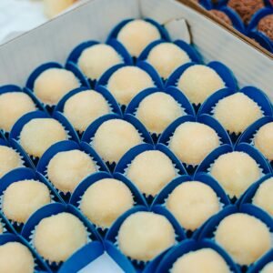 Assorted brigadeiros placed in blue wrappers, perfect for dessert displays.